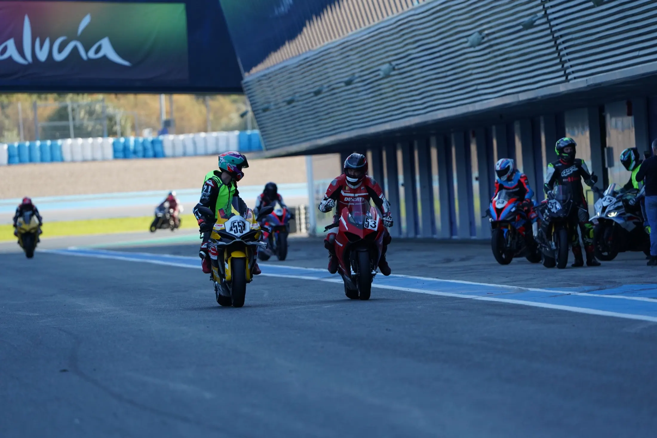 Riders and CRS instructors lined up in the pit lane before a session